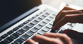 Person typing on a laptop keyboard